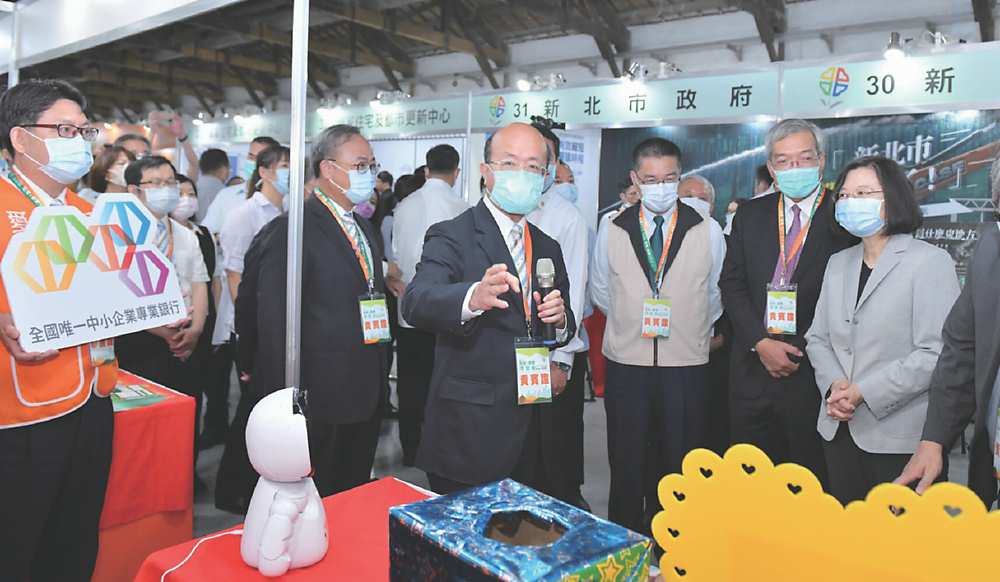 ●總統蔡英文20日出席「危老+都更博覽會」,由臺灣企銀董座黃博怡(持麥克風者)陪同參觀該行攤位。圖/臺灣企銀提供 image
