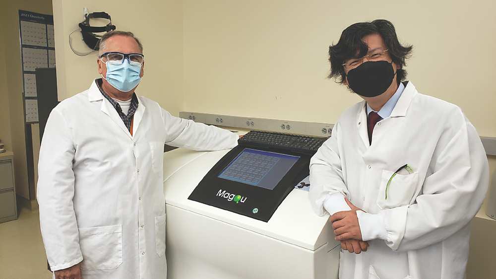 ●磁量生技總經理楊謝樂博士(右)親自遠赴楊森藥廠(Janssen)安裝免疫磁減量微量蛋白質分析儀。圖/磁量生技提供 image