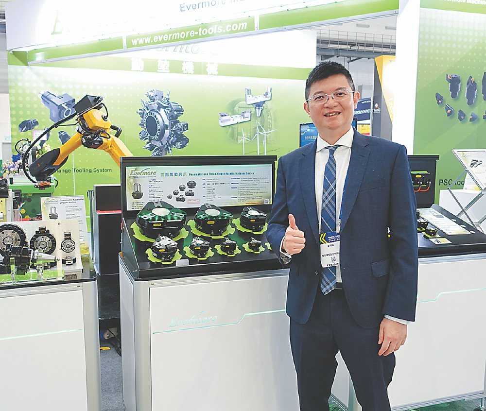 ●勤堃機械總經理廖河誠,和該公司機械手臂及夾爪合影。圖/黃俊榮 image